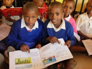 Pupils sitting in the class while reading and looking for the pictures from the book.